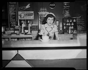 Server Anita Savoie stirring cup behind diner counter
