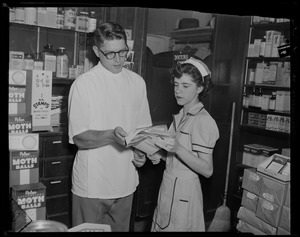 Server Anita Savoie and man, possibly a pharmacist, looking at papers