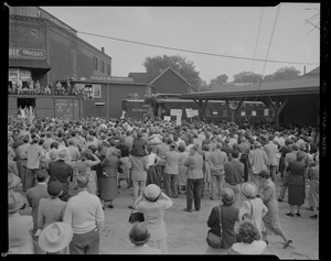 Crowd listening to a person speak on the back of a train during vice presidential candidate Richard Nixon's New England tour
