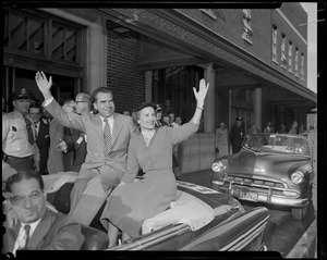 Richard and Pat Nixon waving from open car