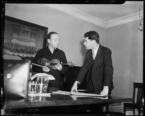 Jascha Heifetz showing a student, Raphael Silverman, how he would finger a difficult bar of music