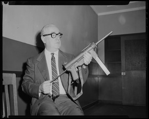 Man holding up and examining gun