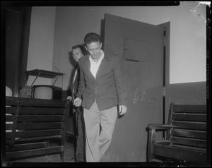 Elmer Burke walking into room while handcuffed to another man