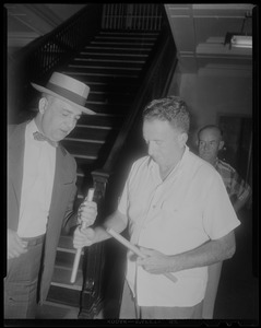 Two men examining bars or pipes