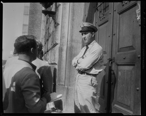 Prison guard standing near door of Charles Street Jail, talking to possible journalist