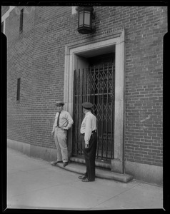 Two officers at gated security door to Charles Street Jail