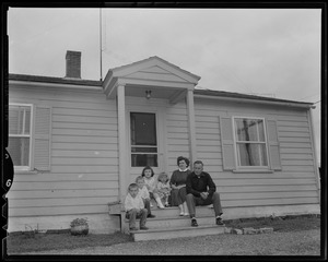 Edward Dahlgren seated on front steps of house with wife Paula and children Brian, Michael, Susan, and Judy