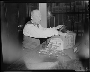 Police Det Earl L. Laird Ballistion at Headquarters is shown as he puts away Trigger Burke's arsenal of firearms which will eventually be destroyed because his case is closed...as shown by the news headlines