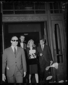 Carroll Baker exiting building with City of Boston greeter Bob DeSemone and two other men