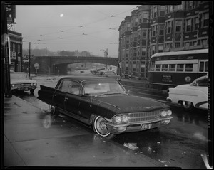 Jerry Ajulio's car, with bullet holes and broken windows, parked near Huntington and South Huntington Avenues as E branch streetcar passes by