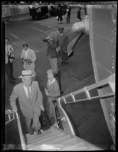 Dr. Paul Dudley White walking up stairs to plane, with flight attendant, skycap, and photographers