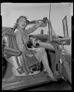 Actress Denise Darcel seated in convertible