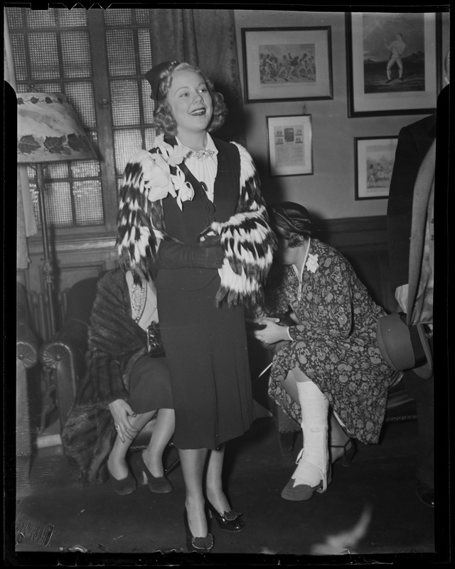 Sonja Henie at party, with others nearby