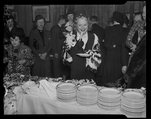 Sonja Henie eating from the buffet line