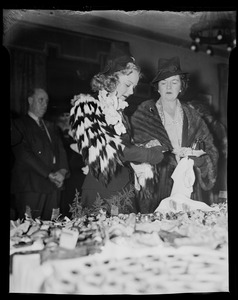 Sonja Henie standing at buffet with other woman