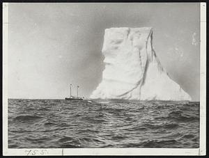 “Chip” Off the Ice Pack.-Thousands of tons of ice towering over the Grenfell Hospital steamer “Maraval.” The masts of the boat are 40 feet, which gives an idea of the massive height of the berg.