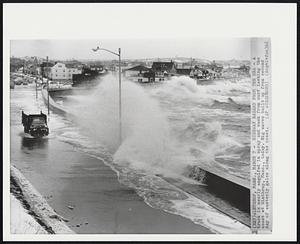Highway Hazard From the Sea - A truck is nearly engulfed in spray and wash from surf lashing the coast at Winthrop, Mass., today. Big waves built up from second day of easterly gales along the coast.