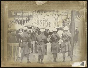 Fort Devens, Mass. MP’s watch from behind barriers as some 150 members of the Student Mobilization Committee picket the main gate hero 11/11. The Boston area students were protesting the Army’s decision to bar anti-war leaflets from the post. Fort Devens authorities have forbidden students to distribute leaflets at the Ayer, Mass. installation.