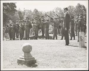 Army honor guard firing salute at cemetery