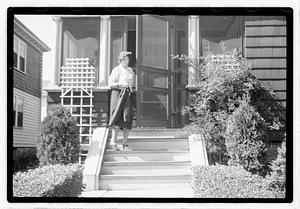 A woman stepping out of a house