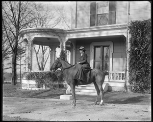 Mrs. L. Talbot on horseback in front of house