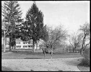 Mrs. L. Talbot on horseback in front of house