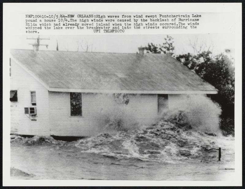 Orleans: High waves from wind swept Pontchartain Lake pound a house 10/4. The high winds were caused by the backlash of Hurricane Hilda which had already moved inland when the high winds occured. The winds whipped the lake over the breakwater and into the streets surrounding the shore.