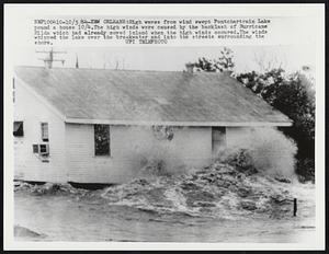 Orleans: High waves from wind swept Pontchartain Lake pound a house 10/4. The high winds were caused by the backlash of Hurricane Hilda which had already moved inland when the high winds occured. The winds whipped the lake over the breakwater and into the streets surrounding the shore.