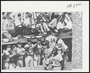 Dodger Greeting--Bill Skowron, first baseman of the Los Angeles Dodgers, gets a warm reception as he reaches the Dodgers’ dugout after hitting the first pitch of the third inning into right field stands for a home run. Dodgers in the dugout at this point of second game of World Series at New York’s Yankee Stadium are, from left Ken McMullen, Sandy Koufax, Don Drysdale, Ron Fairly, Leo Durocher, and at extreme right, manager Walter Alston. Walking, front, is Dodger catcher John Roseboro.