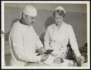 Palm Prints for Baby Because Tiny Baby Fingers Provide Prints too Small for Practical Purposes and Foot Prints are Considered Inadequate After a Ten Day Period, Dr. Gilbert P. Pond, West Suburban Hospital, Chicago, Ill., Has Perfected Palm Prints for Birth Records. Photo No. 2 of This Seroes Shows Dr. Pond and Nurse Lenore Schulze Taking a Palm Print of Baby West