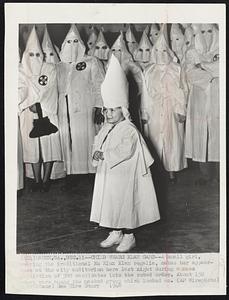 Child Wears Klan Garb--A small girl, wearing the traditional Ku Klux Klan regalia, makes her appearance at the city auditorium here last night during a mass initiation of 300 candidates into the robed order. About 150 women were among the masked group which looked on.