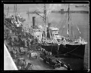 Ice covered fishing boats unloading fish to waiting carts