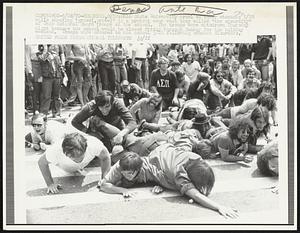 Ohio State University crawl on their stomachs 5/28 while shouting "grovel, grovel" in a protest over what they called "the absurdity" of Ohio National Guard troops at the school. The troops were withdrawn Thursday night because the school would be closed Friday through Sunday for the holiday weekend. Troops were ordered to the school 5/12 following student disorders.