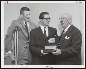 Act of Sportsmanship earns Tommy Salvo, center, 18 - year - old Boston University freshman, Swede Nelson Award at Sheraton Plaza. making presentation is Nils V. "Swede" Nelson as Charley Delborn of the University of Connecticut, whose injury figured in the award, looks on.