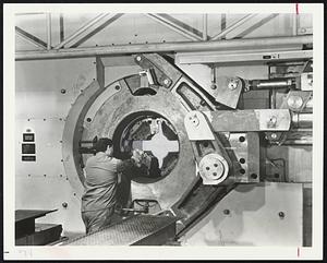 Discouraged Weight-Watchers might consider, if only briefly, the possibilities in this new rotary forger owned by Revere Copper and Brass Co. The four hammers, curved surfaces around workman's hand, can shape considerable bulk. The four striking simultaneously exert a combined pressure of 2,700 tons per blow at the rate of 360 blows per minute.