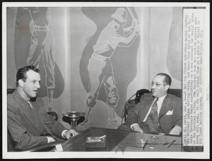 At Bat for Higher Pay -- Stan Musial (left), the National League batting champ, and Owner Fred Saigh of the St. Louis Cardinals begin negotiations on a new contract from Musial today at the Cardinal office. The Cardinal star has said he expects more money this year. On the wall behind them is a mural of Musial in his famed batting stance.