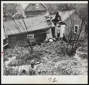 Slide Tumbles House-Three members of the Steve Sholdra family escaped unhurt as a rain-caused earth slide tumbled this house down Beacon Hill slope in south Seattle and broke it in two