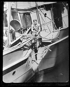 A man sitting on top of a damaged ship
