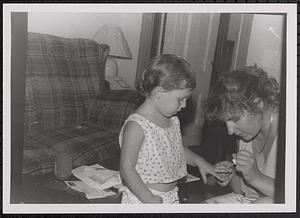 Woman painting a girl's nails