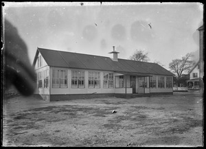 Building with many windows. House nearby