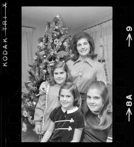 Unidentified woman and children posing with Christmas tree