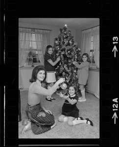Unidentified woman and children posing with Christmas tree
