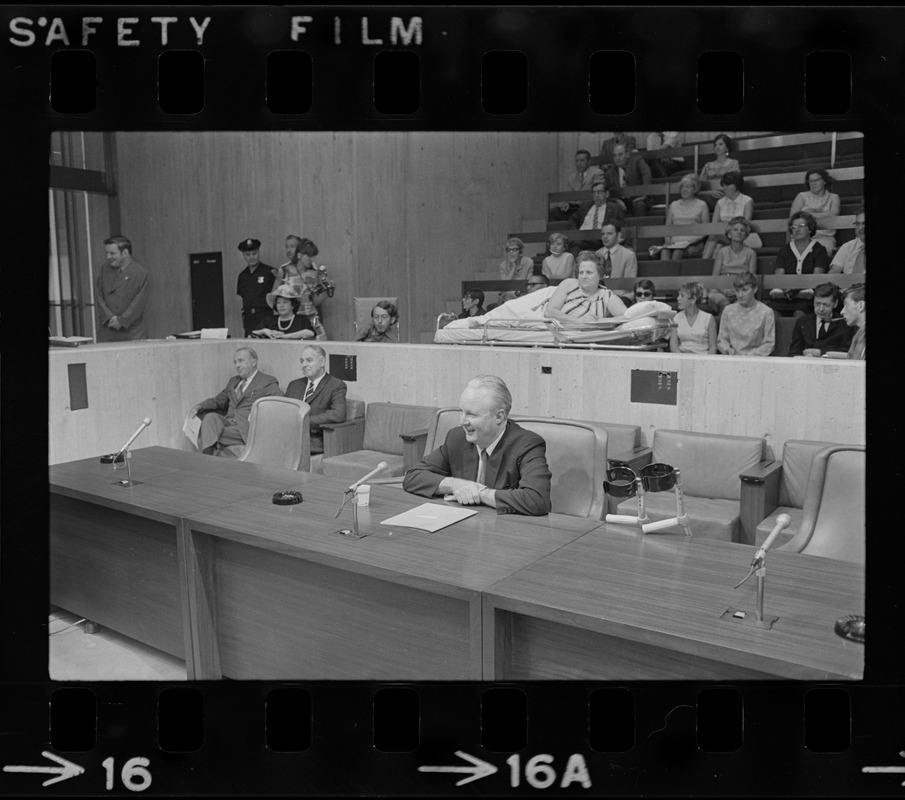 Former Boston John F. Collins addresses City Council hearing on the plight of handicapped persons as Helene Cummings watches from her stretcher-bed