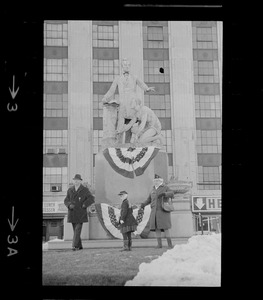 Three people in front of the Emancipation Memorial, Park Square, Boston