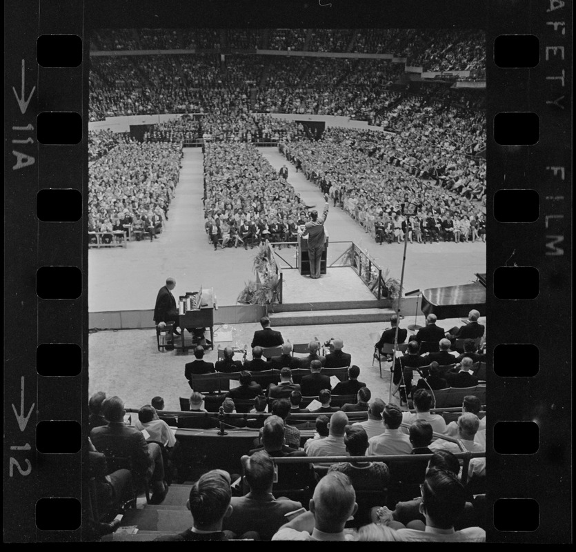 Dr. Billy Graham is barely visible on the stage at Boston Garden where capacity crowd gathered for service Sunday afternoon