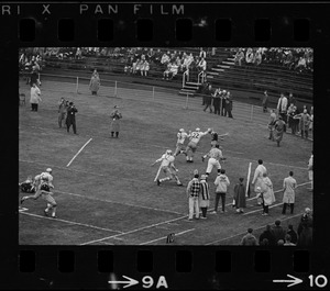 Football players in end zone with arms outstretched to catch the ball