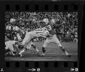 New England Patriots players tackling New York Jets player Bill Mathis (no. 31) in a football game