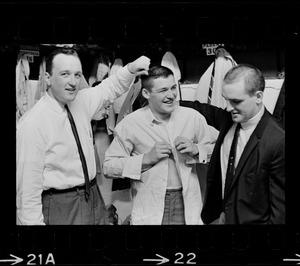 Three Boston Bruins hockey players including Bernie Parent, middle, getting dressed in locker room