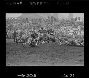 Football players attempting to tackle play with possession of the ball