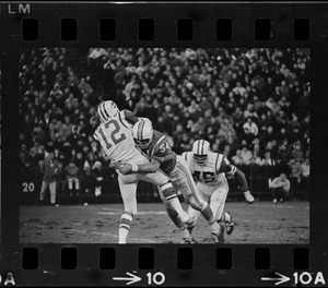 New England Patriot tackling a New York Jet player in a football game